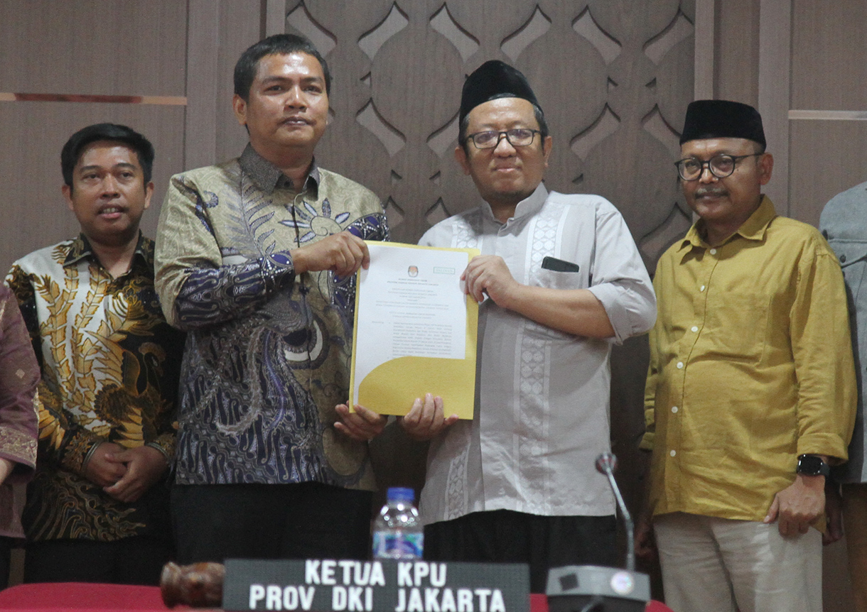 Ketua KPU DKI Jakarta Wahyu Dinata (kiri) memberikan surat penetapan pasangan calon peserta Pilgub DKI Jakarta kepada Ketua tim pemenangan Calon Gubernur Pramono Anung- Calon Wakil Gubernur Rano Karno, Lies Hartono alis Cak Lontong (kanan) di Salemba, Jakarta Pusat, Minggu (22/9/2024).  (BeritaNasional.com/ Oke Atmaja)