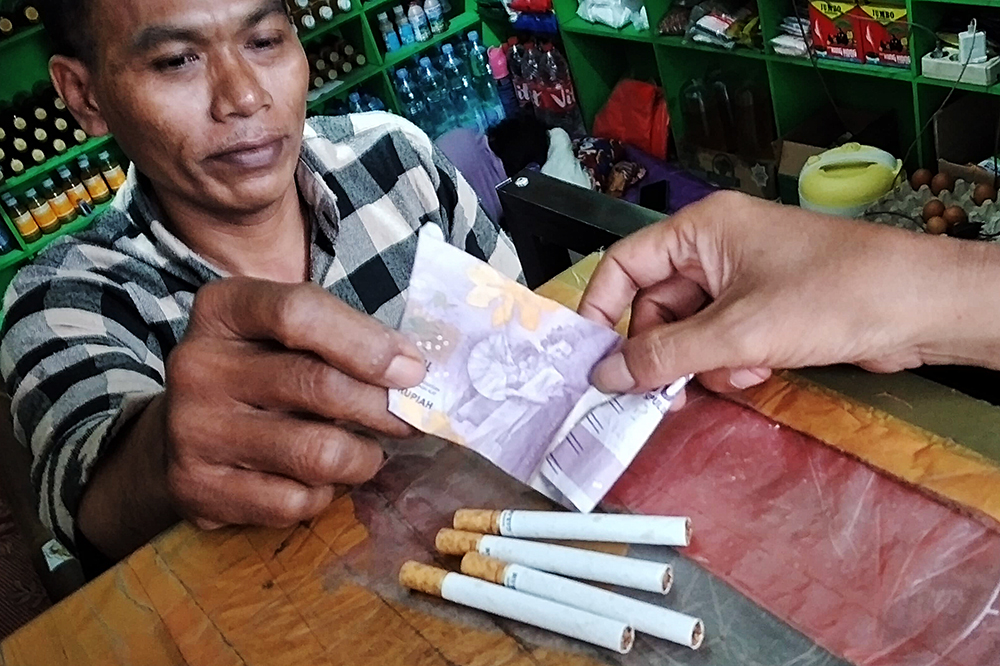 Pedagang melayani pembeli rokok ketengan. (BeritaNasional/Elvis Sendouw)