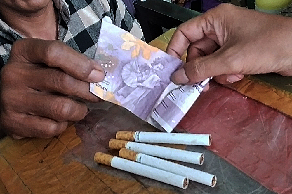 Pedagang melayani pembeli rokok ketengan. (BeritaNasional/Elvis Sendouw)