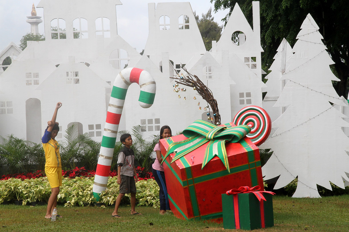 Sejumlah warga bermain dengan latar belakang dekorasi khas Natal di Taman Lapangan Banteng, Jakarta, Rabu (25/12/2024).(BeritaNasional.com/Oke Atmaja)