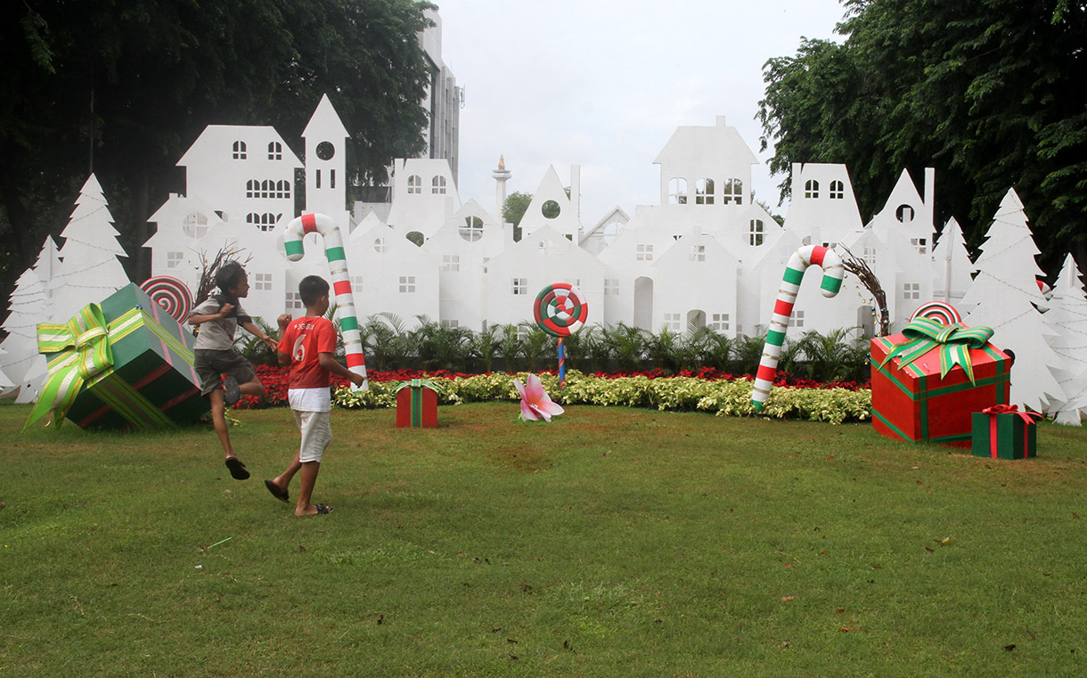 Sejumlah warga bermain dengan latar belakang dekorasi khas Natal di Taman Lapangan Banteng, Jakarta, Rabu (25/12/2024).(BeritaNasional.com/Oke Atmaja)