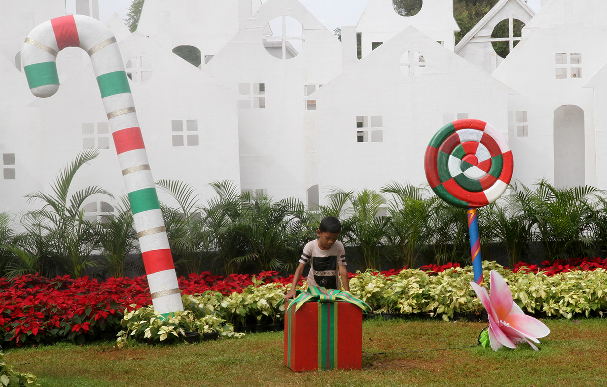 Sejumlah warga bermain dengan latar belakang dekorasi khas Natal di Taman Lapangan Banteng, Jakarta, Rabu (25/12/2024).(BeritaNasional.com/Oke Atmaja)