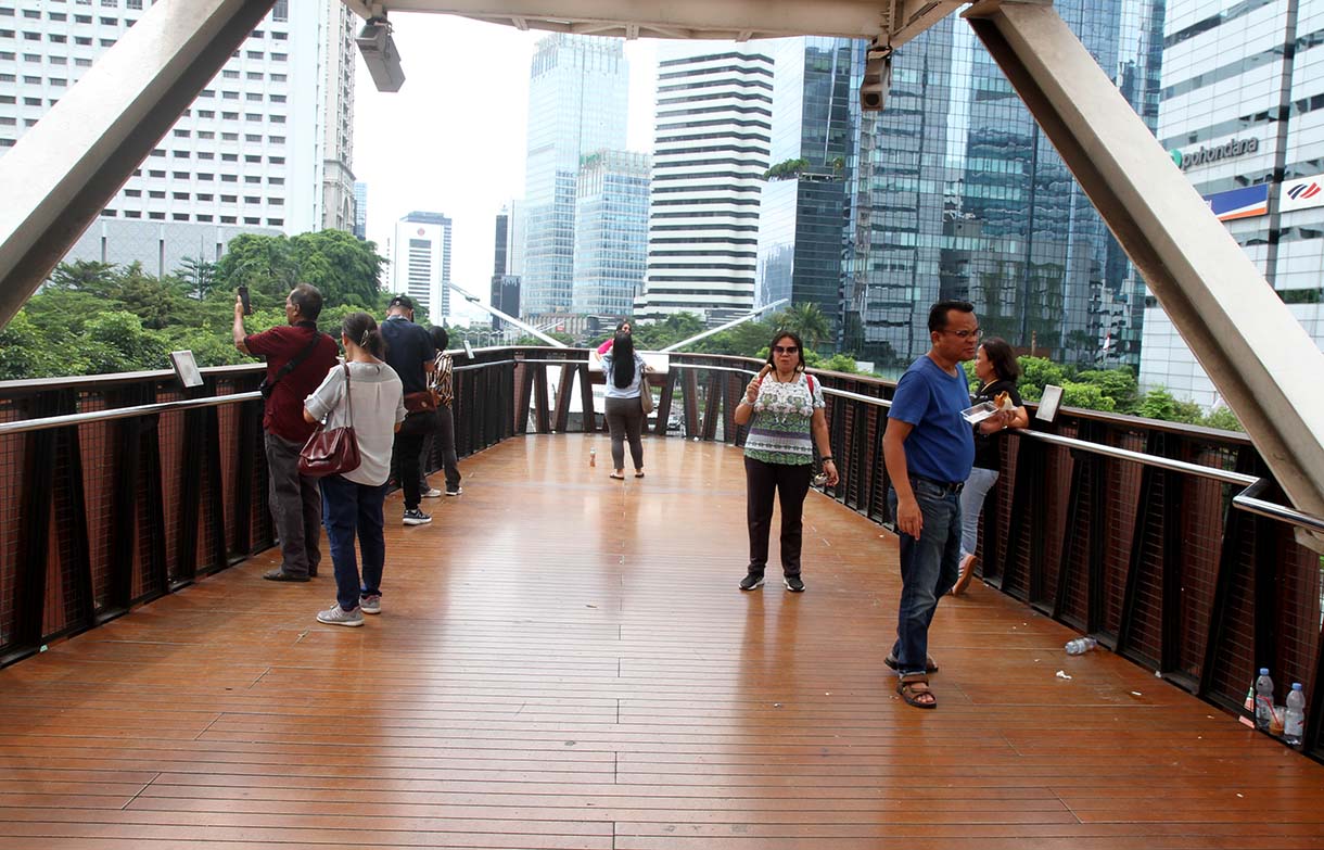 Warga berfoto di Jembatan Penyeberangan Orang (JPO) 'Kapal Pinisi' di jalan Jenderal Sudirman, Jakarta, Senin (12/5/2025). (Beritanasional.com/Oke Atmaja)