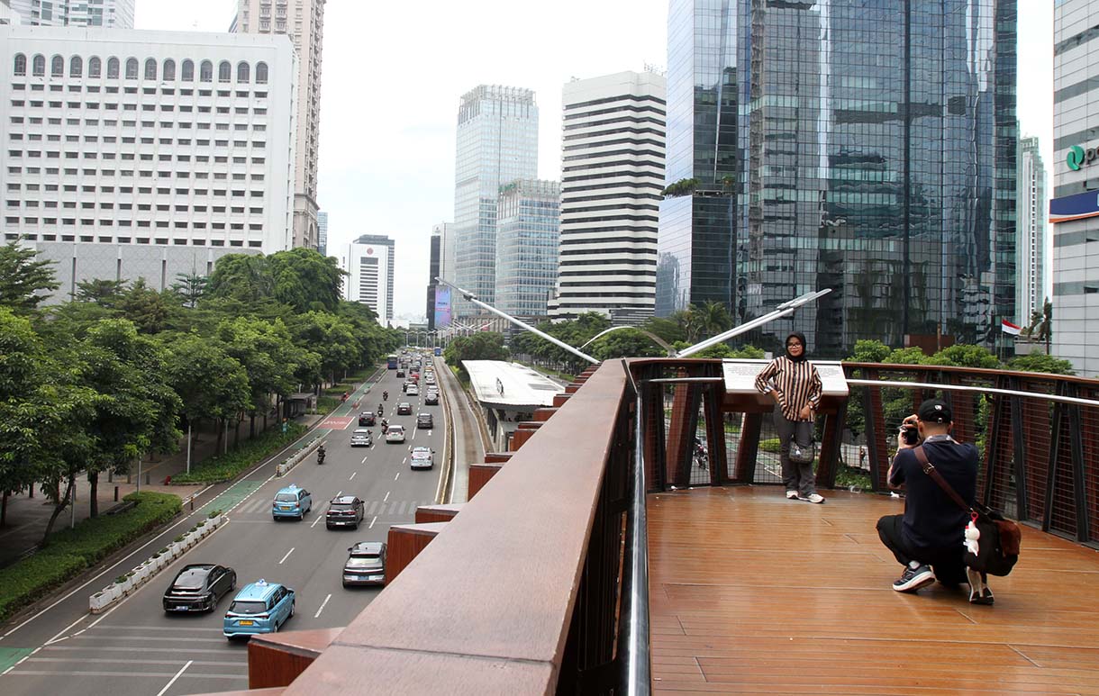 Warga berfoto di Jembatan Penyeberangan Orang (JPO) 'Kapal Pinisi' di jalan Jenderal Sudirman, Jakarta, Senin (12/5/2025). (Beritanasional.com/Oke Atmaja)