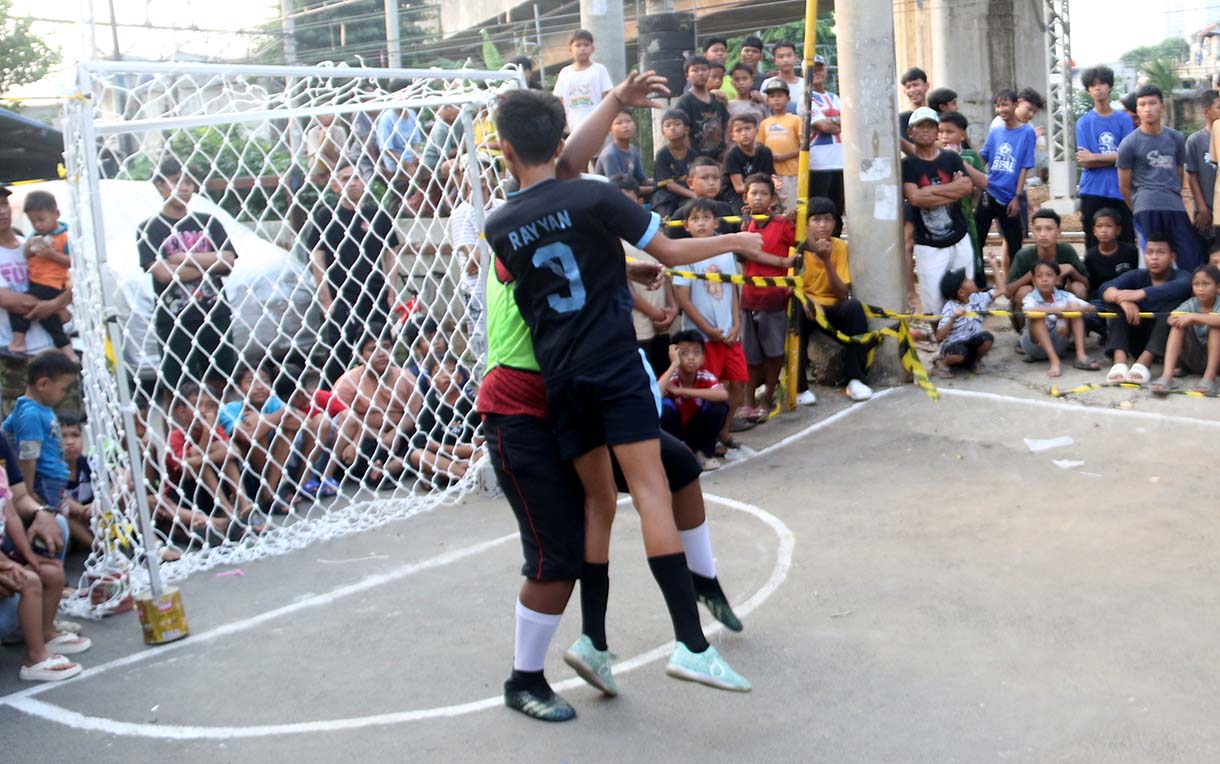 Anak-anak mengikuti pertandingan Turnamen Sepak Bola "Liga Aspal" U-13 di lapangan sederhana kawasan permukiman padat pinggir rel RT 09/RW 08, Menteng Jaya, Jakarta, Sabtu (20/6/2026). (Beritanasional.com/Oke Atmaja)