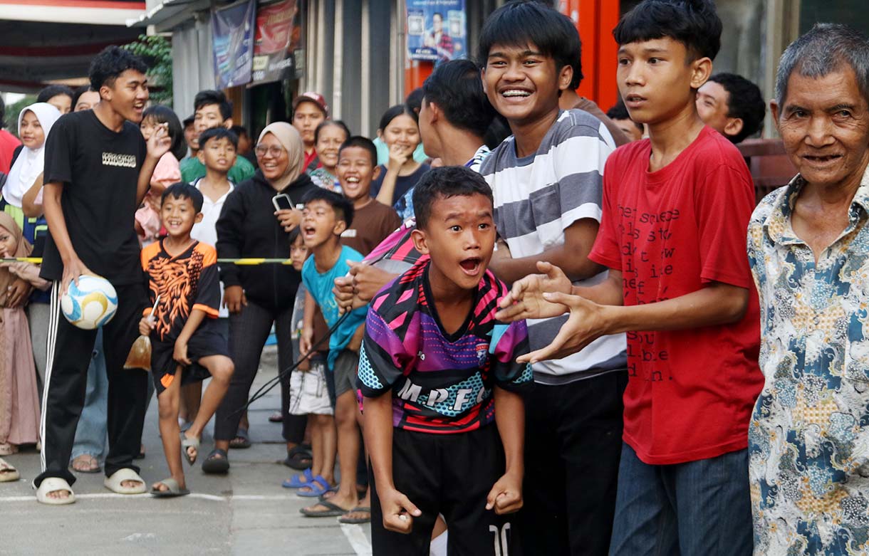 Anak-anak mengikuti pertandingan Turnamen Sepak Bola "Liga Aspal" U-13 di lapangan sederhana kawasan permukiman padat pinggir rel RT 09/RW 08, Menteng Jaya, Jakarta, Sabtu (20/6/2026). (Beritanasional.com/Oke Atmaja)