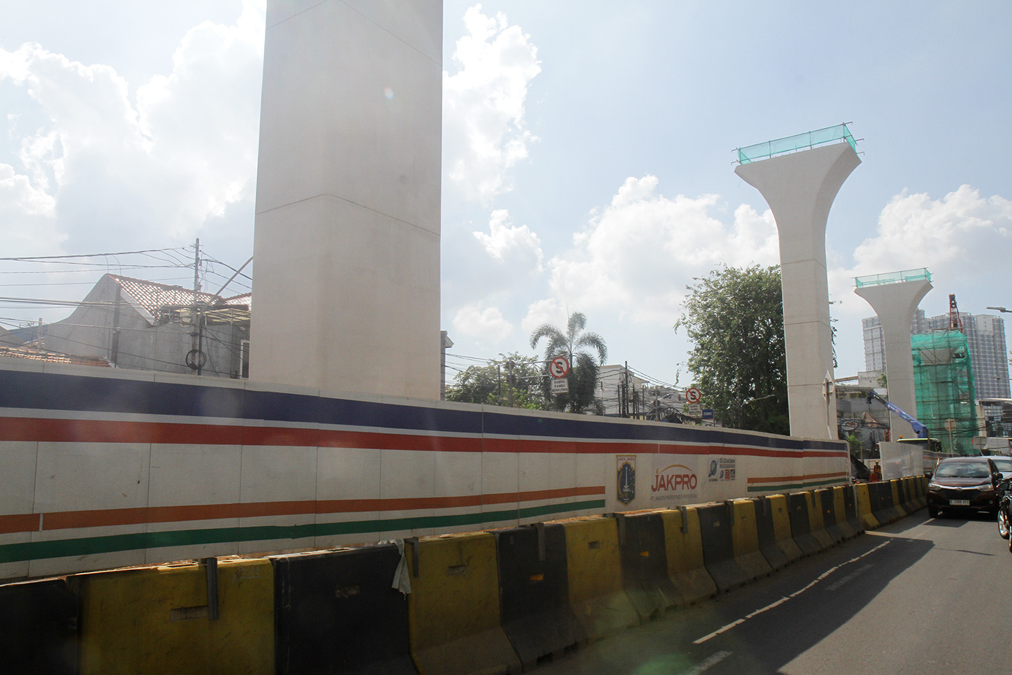 Kendaraan melintas disamping proyek pembangunan jalur kereta ringan atau Light Rail Transit (LRT) Jakarta fase 1B rute Velodrome-Manggarai di kawasan Manggarai, Jakarta, Rabu (26/6/2024). (BeritaNasional.Com/Oke Atmaja)