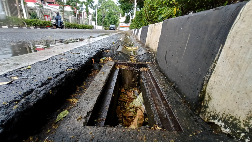 Lubang Drainase tanpa Penutup Besi di Jakarta Kendaraan melintas di samping lubang drainase yang besi penutupnya hilang di Jalan Proklamasi, Jakarta, Minggu (11/5/2025). (Berita nasional.com/ Oke Atmaja)