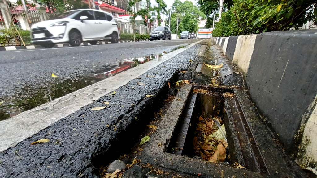 Lubang Drainase tanpa Penutup Besi di Jakarta Kendaraan melintas di samping lubang drainase yang besi penutupnya hilang di Jalan Proklamasi, Jakarta, Minggu (11/5/2025). (Berita nasional.com/ Oke Atmaja)