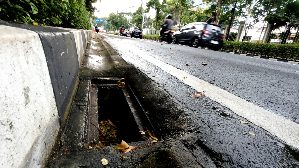Lubang Drainase tanpa Penutup Besi di Jakarta Kendaraan melintas di samping lubang drainase yang besi penutupnya hilang di Jalan Proklamasi, Jakarta, Minggu (11/5/2025). (Berita nasional.com/ Oke Atmaja)