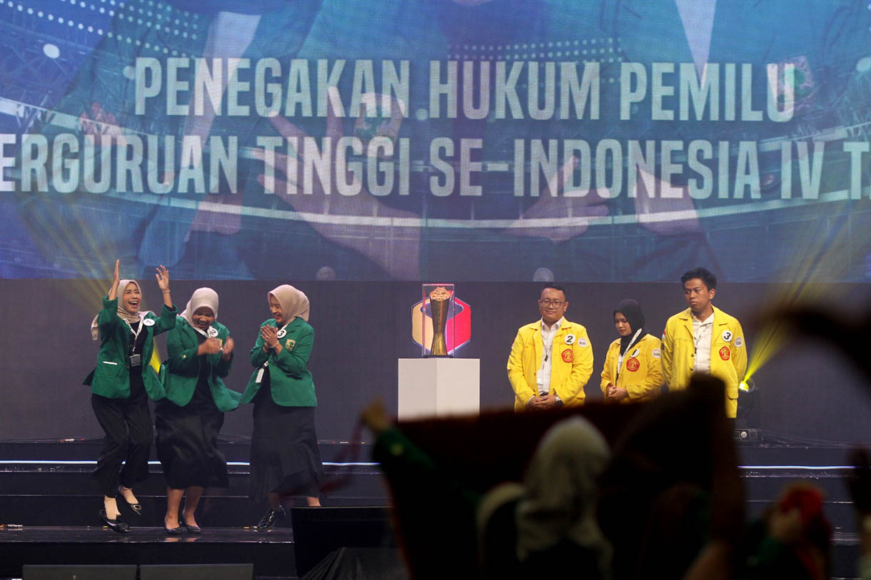 Ketua Bawaslu RI Rahmat Bagja memberikan piagam penghargaan Juara I kepada peserta dari Universitas Andalas di akhir Kompetisi Debat Penegakan Hukum Pemilu Perguruan Tinggi se-Indonesia yang berlangsung di Jakarta, Rabu (23/10/202024) malam. (BeritaNasional.com/Oke Atmaja)