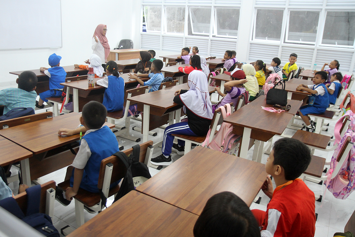 Seorang guru memberikan arahan kepada siswa baru saat mengikuti Masa Pengenalan Lingkungan Sekolah (MPLS) pada hari pertama masuk sekolah tahun ajaran 2025-2026 di SD Negeri 01/02 Cikini, Jakarta, Senin (14/7/2025).  (Beritanasional.com/Oke Atmaja)