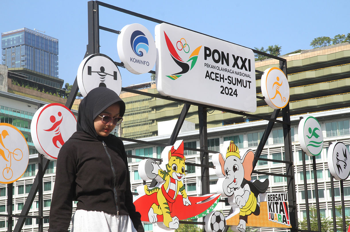 Warga berfoto berlatar belakang maskot PON XXI Tahun 2024 di Bundaran HI, Jakarta, Minggu (8/9/2024). (BeritaNasional.com/ Oke Atmaja)