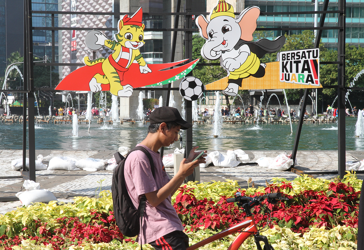 Warga berfoto berlatar belakang maskot PON XXI Tahun 2024 di Bundaran HI, Jakarta, Minggu (8/9/2024). (BeritaNasional.com/ Oke Atmaja)