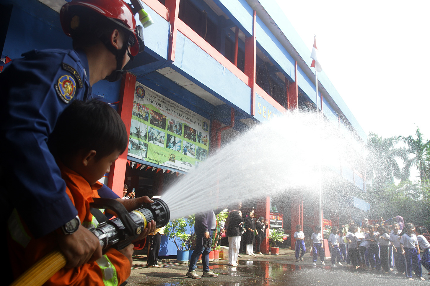 Sejumlah anak TK mencoba menyemprot air dengan selang saat mengunjungi kantor Dinas Pemadam Kebakaran dan Penyalamatan di Jalan Matraman Raya, Jakarta, Sabtu (18/5/2024).  (BeritaNasional.com/Oke Atmaja)