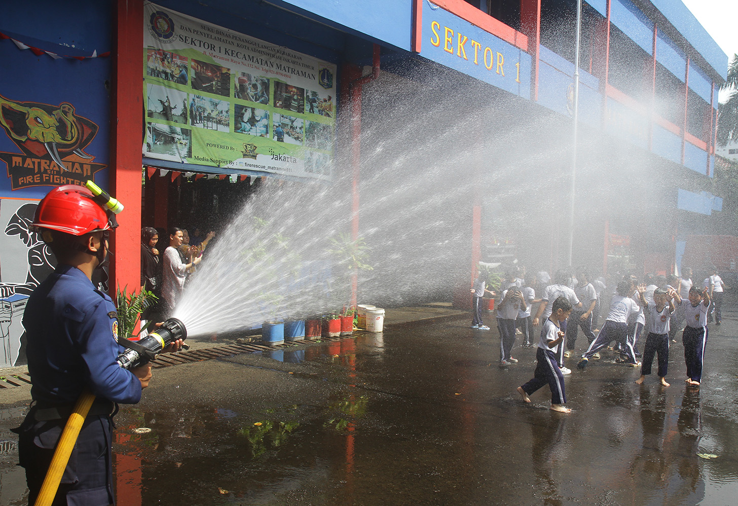 Sejumlah anak TK mencoba menyemprot air dengan selang saat mengunjungi kantor Dinas Pemadam Kebakaran dan Penyalamatan di Jalan Matraman Raya, Jakarta, Sabtu (18/5/2024).  (BeritaNasional.com/Oke Atmaja)