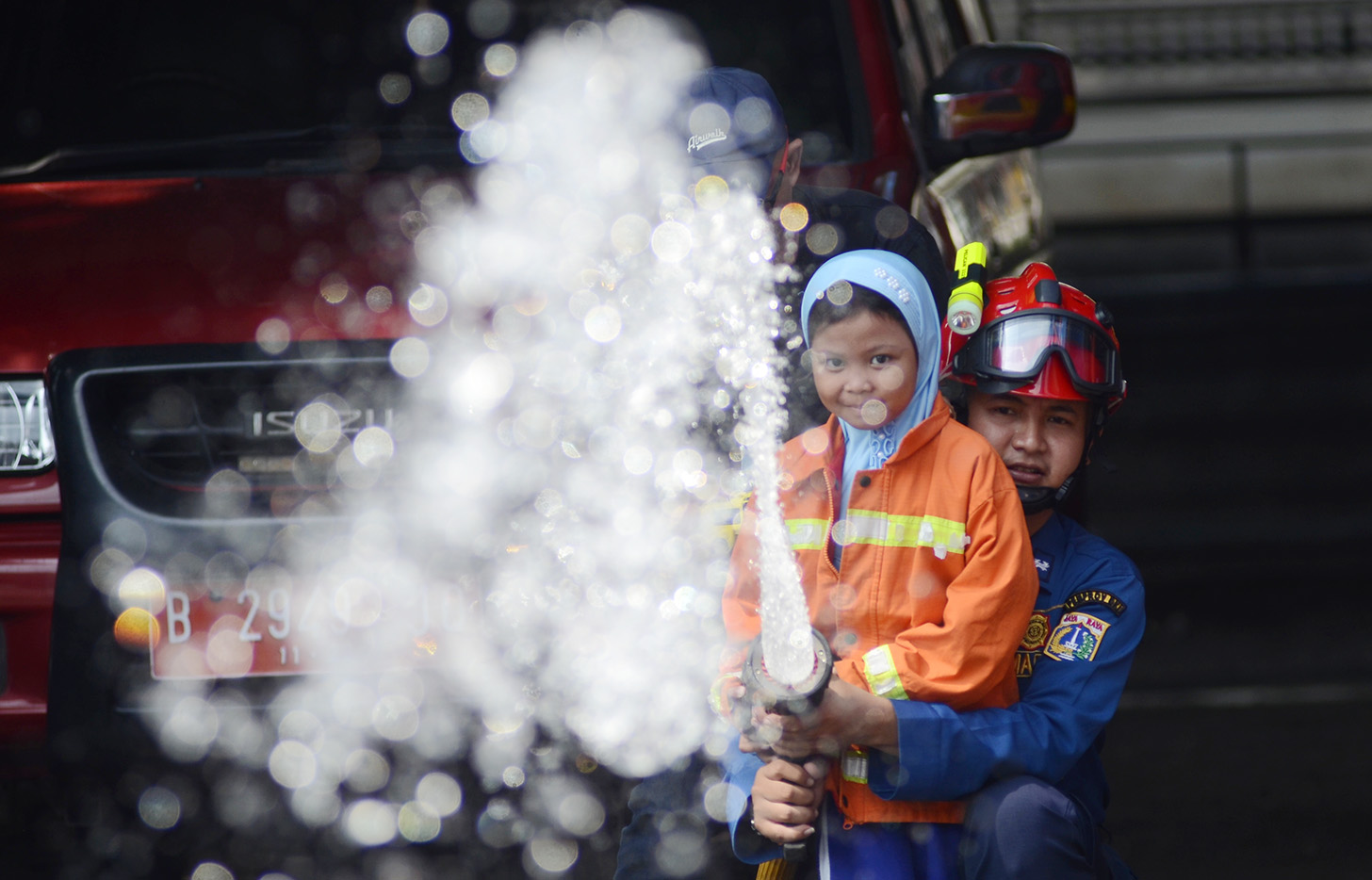 Sejumlah anak TK mencoba menyemprot air dengan selang saat mengunjungi kantor Dinas Pemadam Kebakaran dan Penyalamatan di Jalan Matraman Raya, Jakarta, Sabtu (18/5/2024).  (BeritaNasional.com/Oke Atmaja)