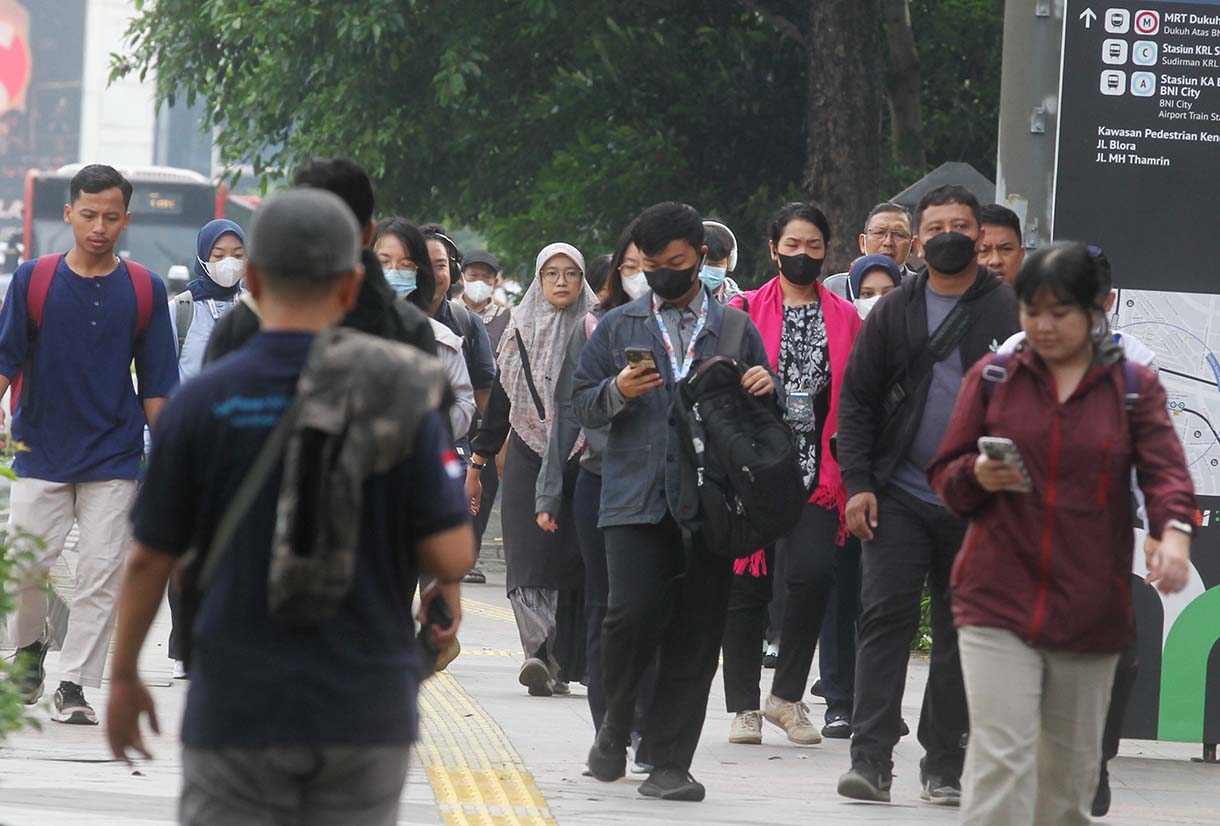 Pekerja melintas di Jalan Jenderal Sudirman, Jakarta Pusat, Rabu (14/5/2025). (Beritanasional.com/Oke Atmaja)