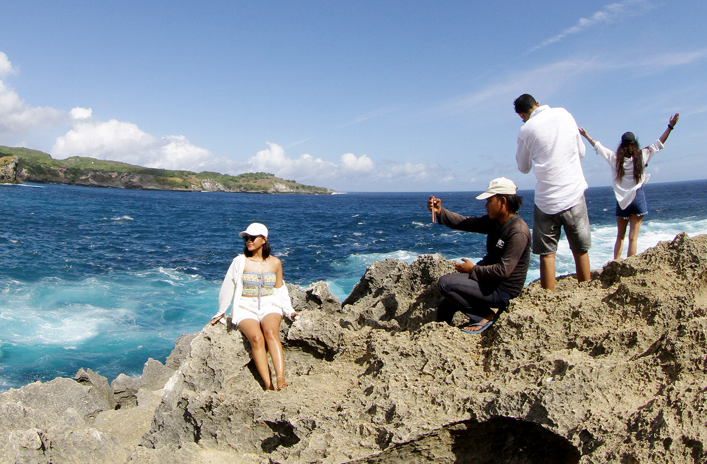 Pengunjung berfoto berlatar pantai Diamond Beach di Nusa Penida, Bali, Minggu (2/6/2024). (BeritaNasional.Com/Oke Atmaja)