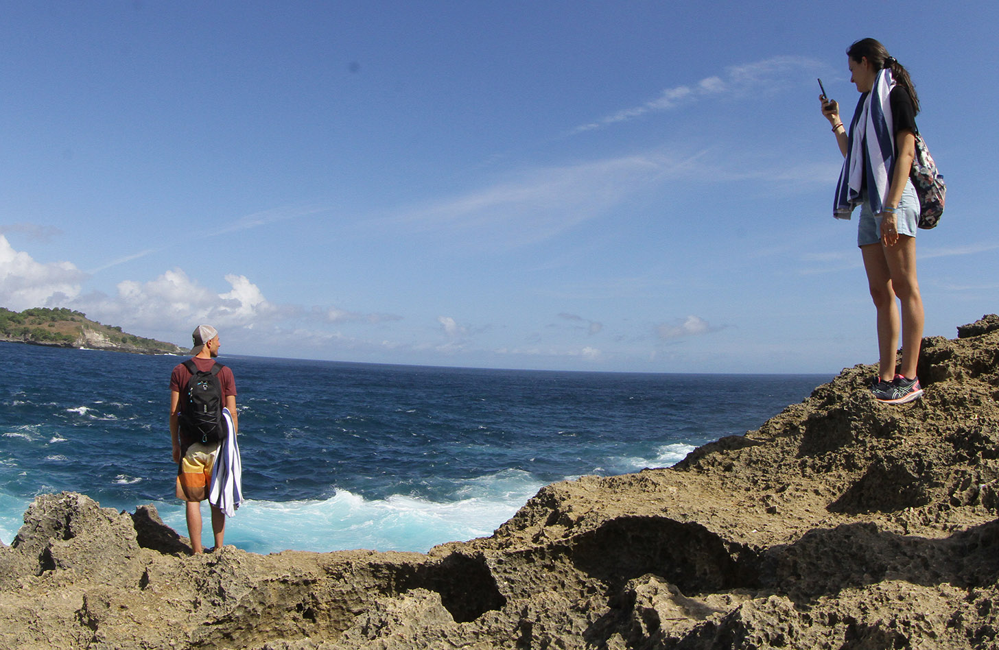 Pengunjung berfoto berlatar pantai Diamond Beach di Nusa Penida, Bali, Minggu (2/6/2024). (BeritaNasional.Com/Oke Atmaja)