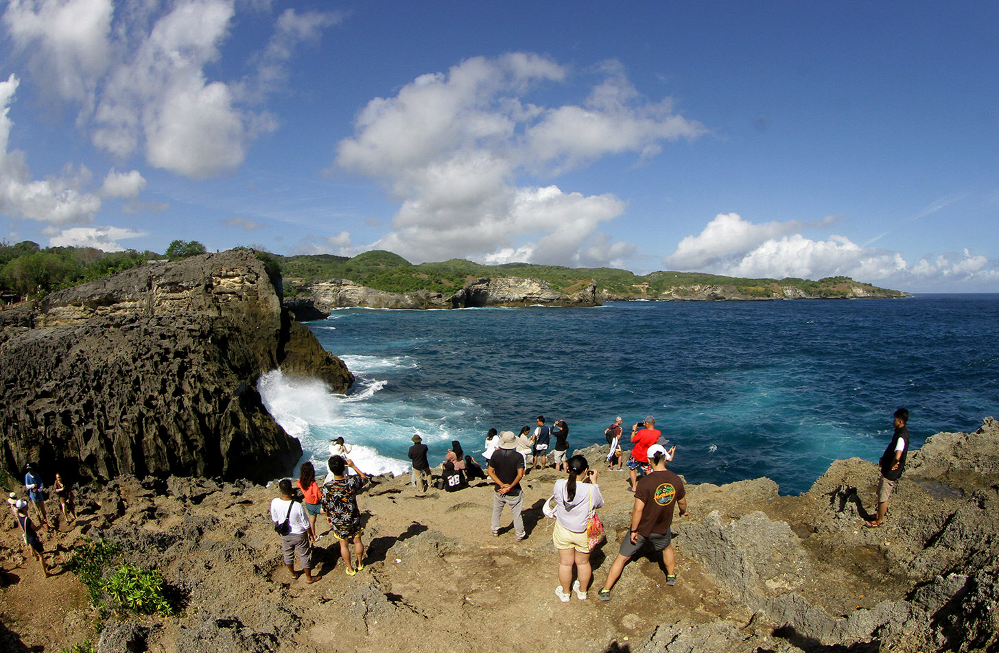 Pengunjung berfoto berlatar pantai Diamond Beach di Nusa Penida, Bali, Minggu (2/6/2024). (BeritaNasional.Com/Oke Atmaja)