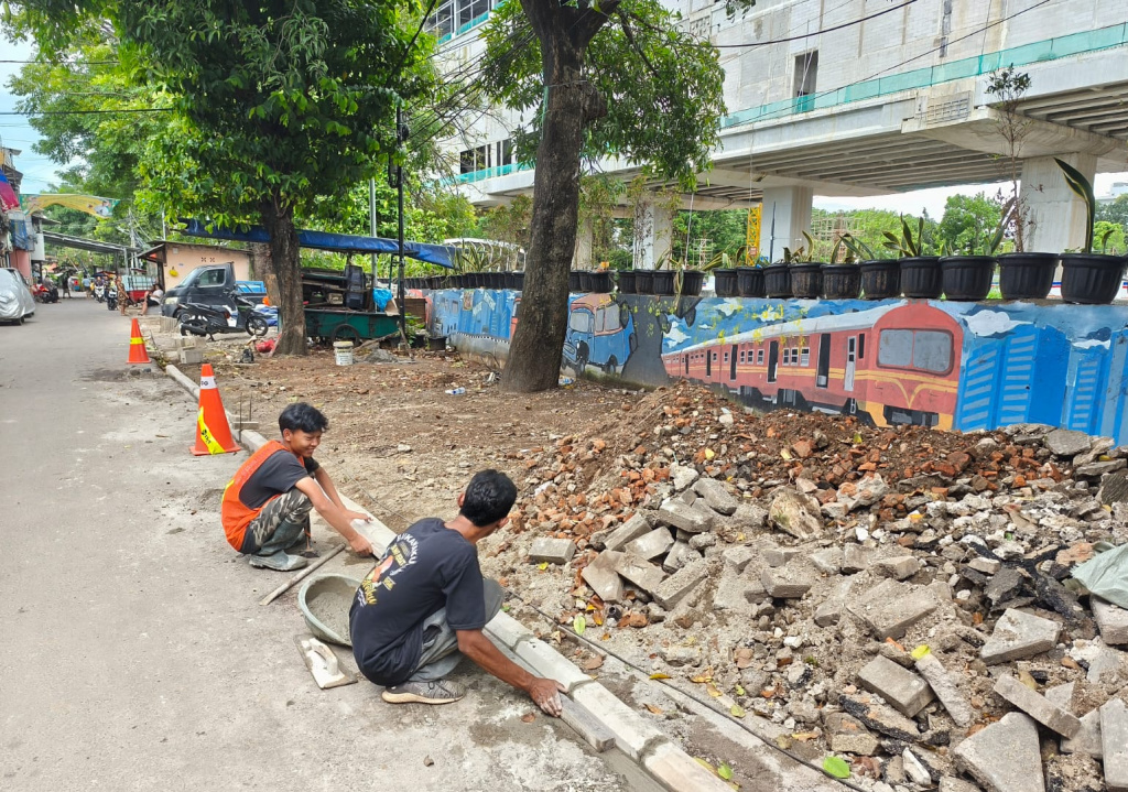 Pekerja menyelesaikan proyek revitalisasi trotoar di Menteng Tenggulun, Jakarta, Jumat (10/4/2026). (Beritanasional.com/Oke Atmaja)