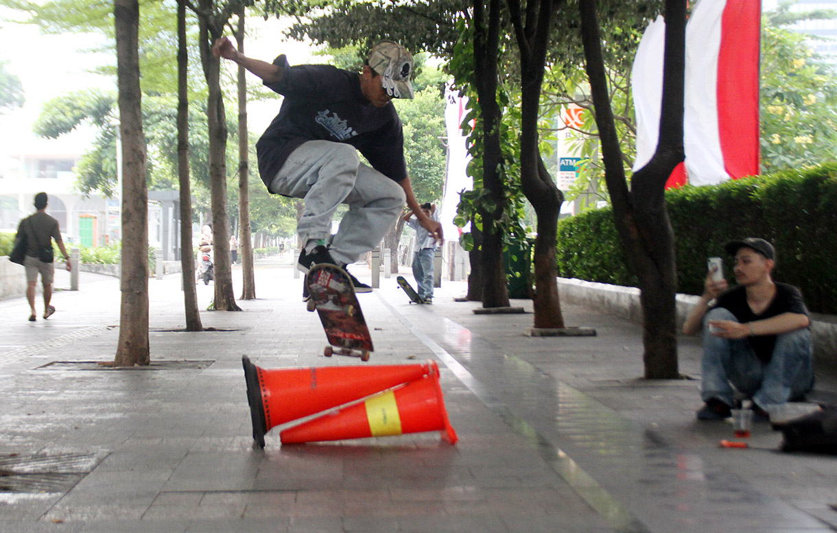 Seorang pemuda bermain skateboard di kawasan Sudirman, Jakarta, Minggu (28/7/2024).  (BeritaNasional.com/Oke Atmaja)