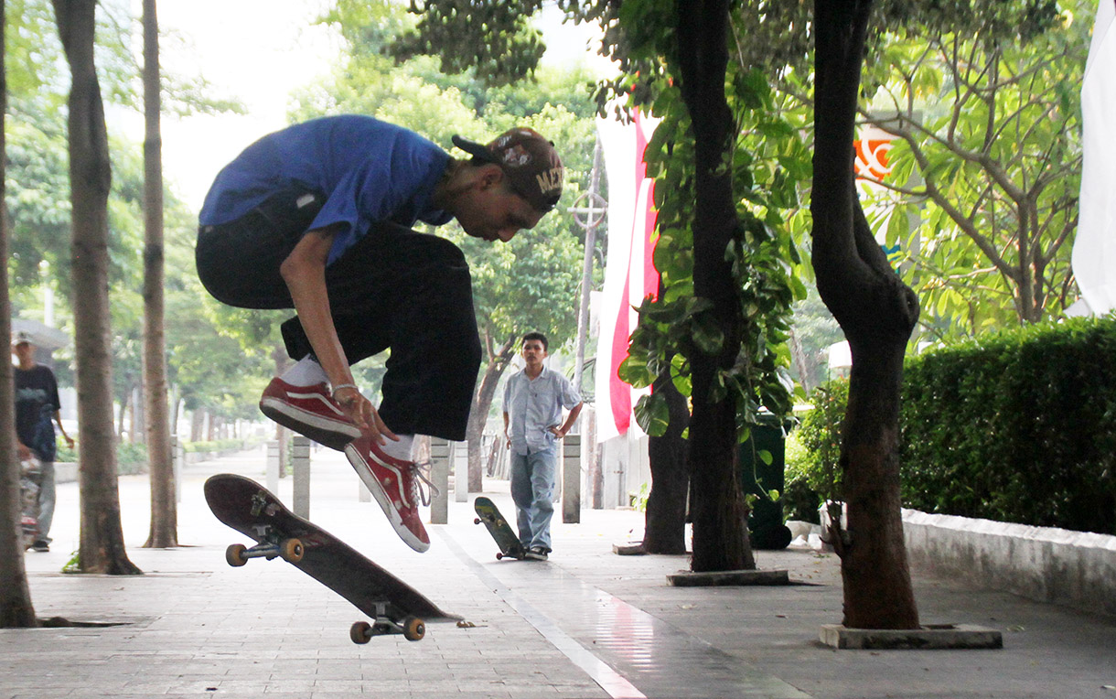 Seorang pemuda bermain skateboard di kawasan Sudirman, Jakarta, Minggu (28/7/2024).  (BeritaNasional.com/Oke Atmaja)