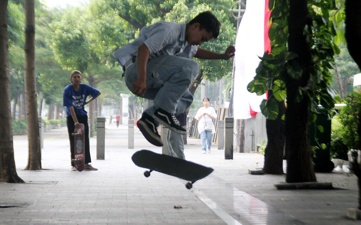 Seorang pemuda bermain skateboard di kawasan Sudirman, Jakarta, Minggu (28/7/2024).  (BeritaNasional.com/Oke Atmaja)