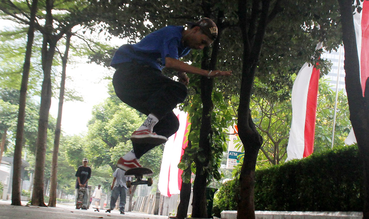 Seorang pemuda bermain skateboard di kawasan Sudirman, Jakarta, Minggu (28/7/2024).  (BeritaNasional.com/Oke Atmaja)