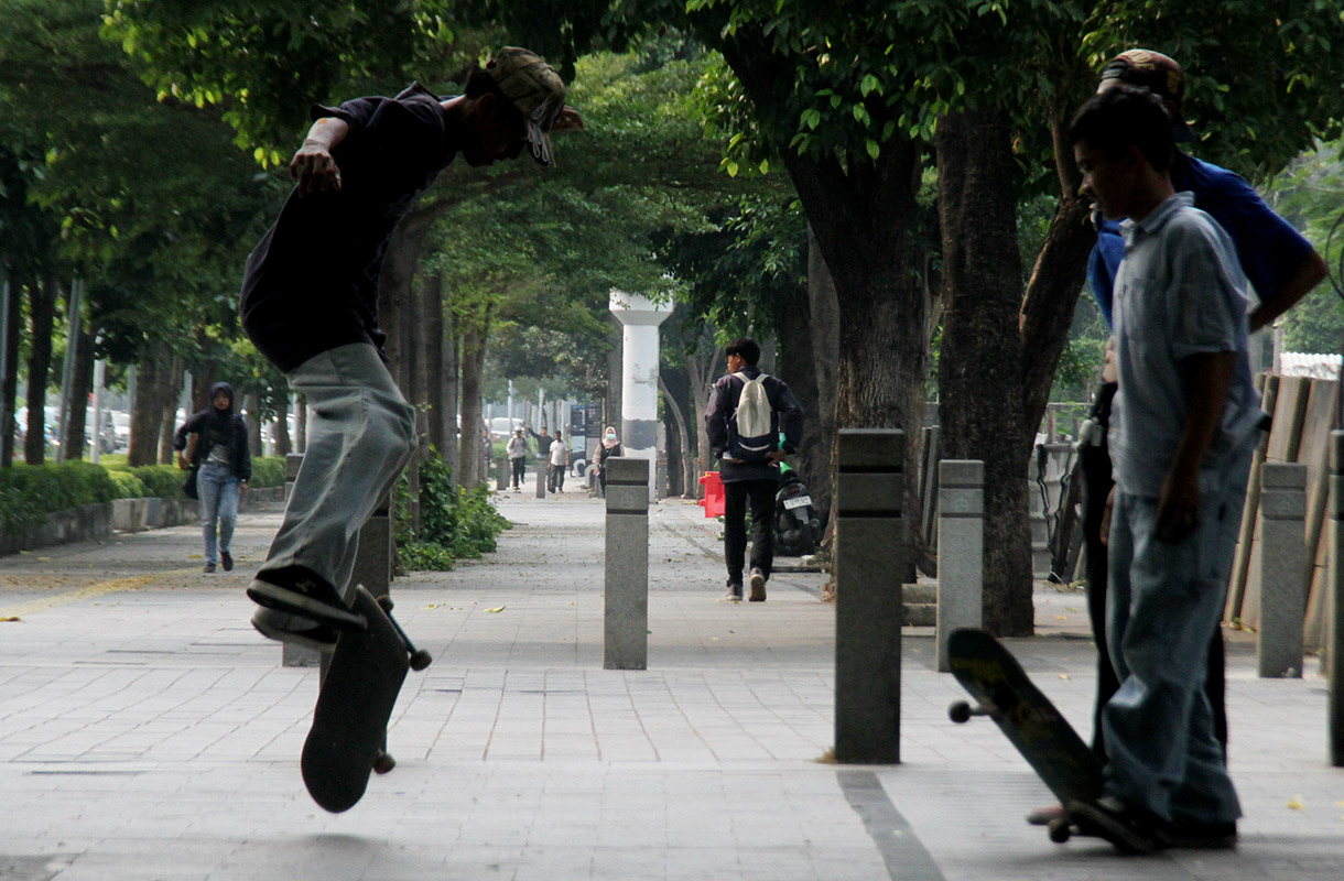 Seorang pemuda bermain skateboard di kawasan Sudirman, Jakarta, Minggu (28/7/2024).  (BeritaNasional.com/Oke Atmaja)