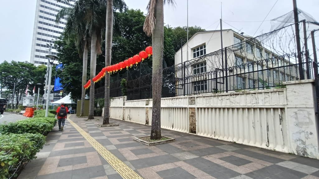 Warga melintas di samping bekas gedung Kedutaan Besar Inggris di Baundara HI, Jakarta, Rabu (11/02/2026).  (Beritanasional.com/Oke Atmaja)