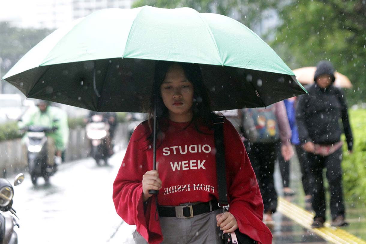 Pejalan kaki memakai payung, melintas di Pedestrian Kawasan Sudirman-Thamrin, Dukuh Atas, Jakarta, saat hujan mengguyur, Selasa (10/3/2026). (Beritanasional.com/Oke Atmaja)