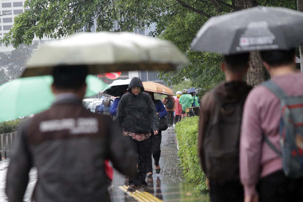 Pejalan kaki memakai payung, melintas di Pedestrian Kawasan Sudirman-Thamrin, Dukuh Atas, Jakarta, saat hujan mengguyur, Selasa (10/3/2026). (Beritanasional.com/Oke Atmaja)