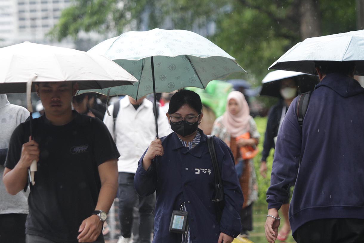 Pejalan kaki memakai payung, melintas di Pedestrian Kawasan Sudirman-Thamrin, Dukuh Atas, Jakarta, saat hujan mengguyur, Selasa (10/3/2026). (Beritanasional.com/Oke Atmaja)