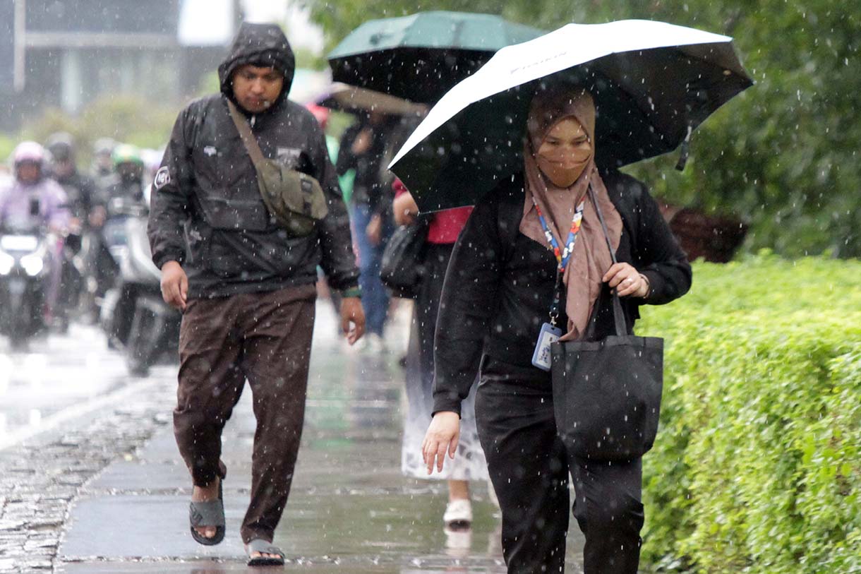 Pejalan kaki memakai payung, melintas di Pedestrian Kawasan Sudirman-Thamrin, Dukuh Atas, Jakarta, saat hujan mengguyur, Selasa (10/3/2026). (Beritanasional.com/Oke Atmaja)