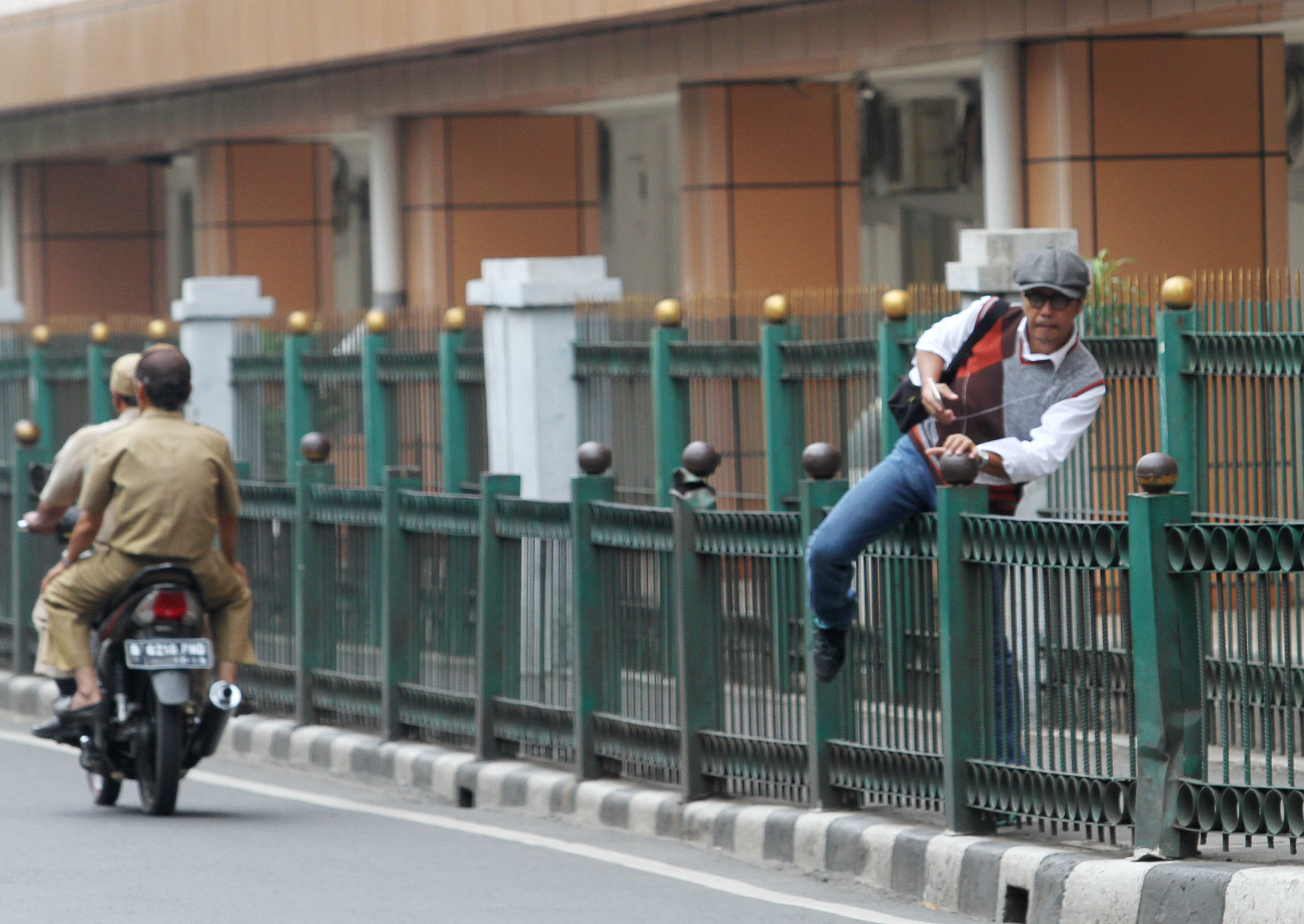 Penumpang KRL melompati pagar pembatas di depan Stasiun Cikini, Jalan Cikini Raya, Jakarta Pusat, Rabu (20/3/2024).  (IndonesiaGlobe/Oke Atmaja)