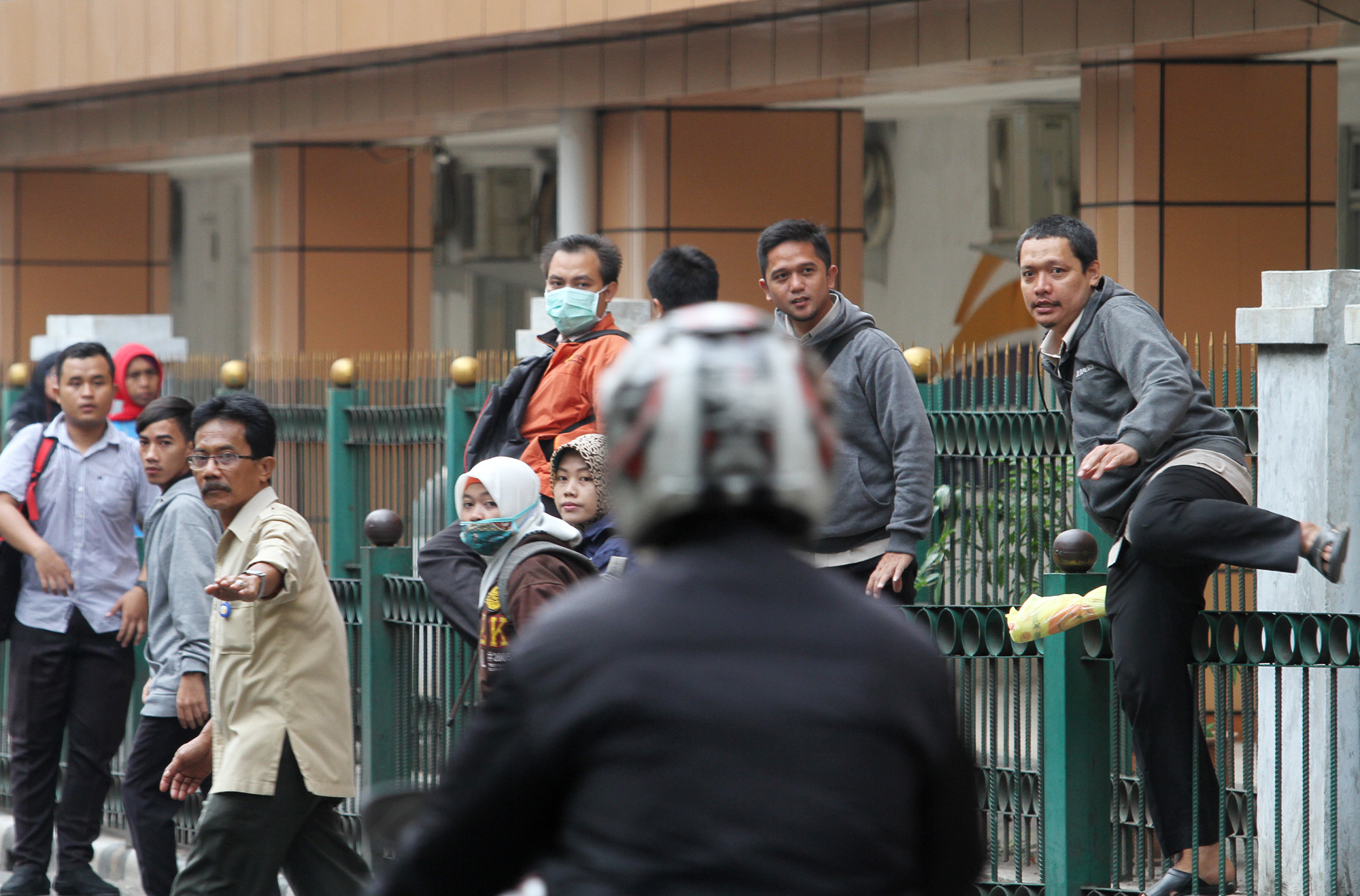 Penumpang KRL melompati pagar pembatas di depan Stasiun Cikini, Jalan Cikini Raya, Jakarta Pusat, Rabu (20/3/2024).  (IndonesiaGlobe/Oke Atmaja)