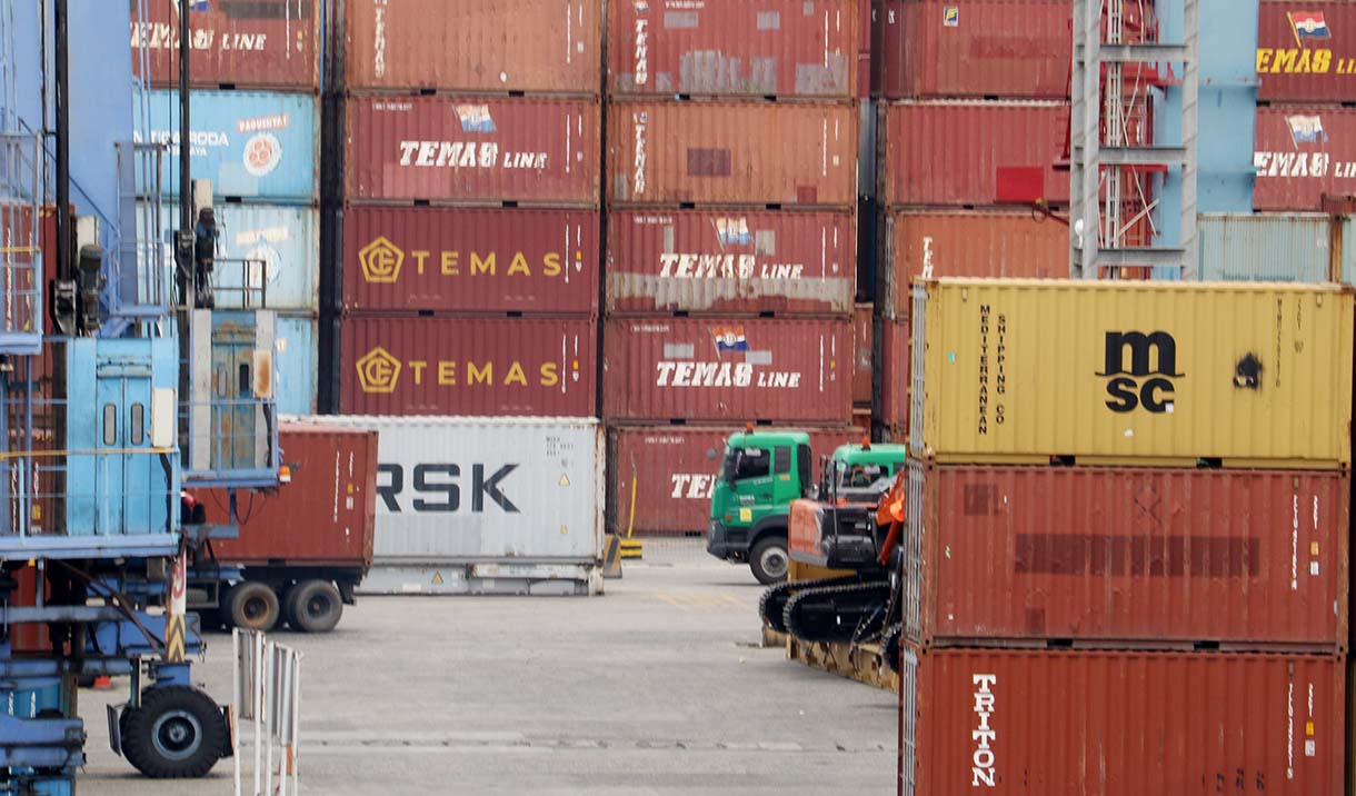 Petugas berjaga di samping peti kemas di Pelabuhan Tanjung Priok, Jakarta, Jumat (3/10/2025).  (Beritanasional.com/Oke Atmaja)