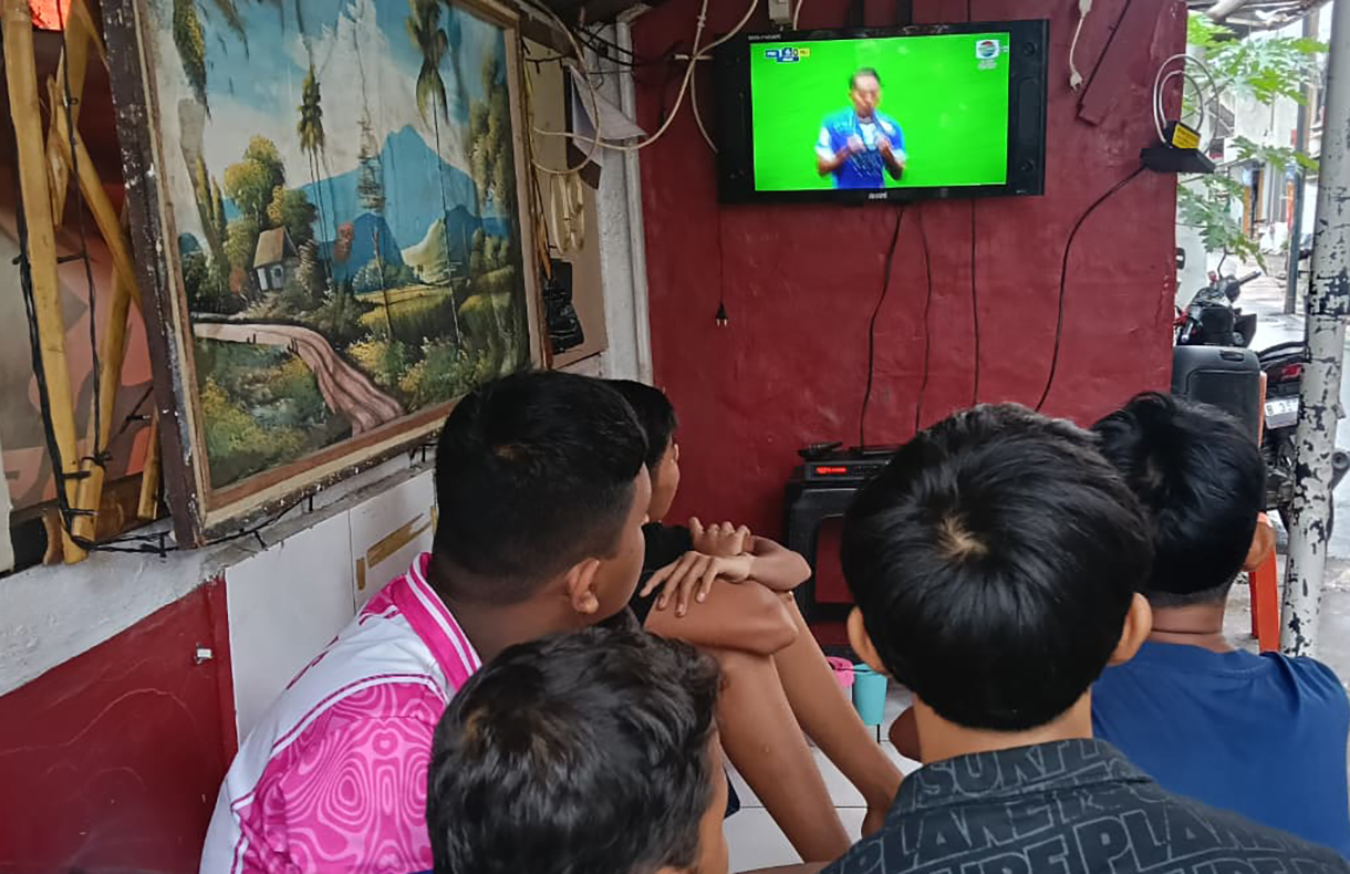 Sejumlah warga nonton bareng siaran langsung pertandingan sepak bola Super League antara Persib melawan Persija  di Menteng Jaya, Jakarta, Selasa (25/5/2025). (Beritanasional.com/Oke Atmaja)