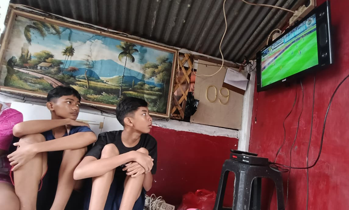 Sejumlah warga nonton bareng siaran langsung pertandingan sepak bola Super League antara Persib melawan Persija  di Menteng Jaya, Jakarta, Selasa (25/5/2025). (Beritanasional.com/Oke Atmaja)