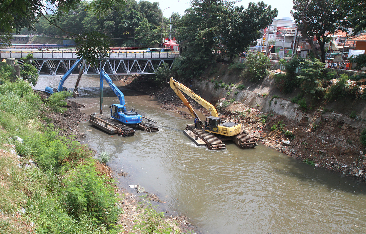 Pekerja menggunakan ekskavator mengeruk lumpur endapan Kali Ciliwung di Bidara Cina, Jakarta, Minggu(15/9/2024).  (BeritaNasional.com/ Oke Atmaja)