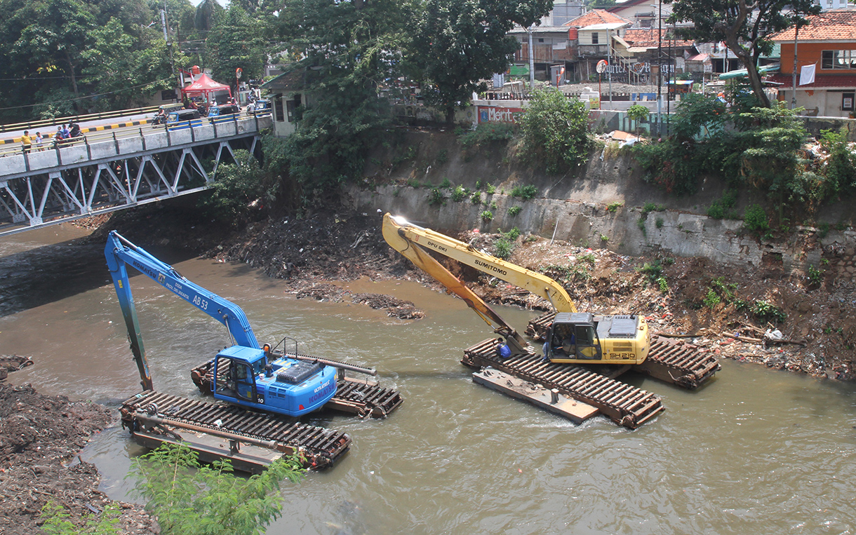 Pekerja menggunakan ekskavator mengeruk lumpur endapan Kali Ciliwung di Bidara Cina, Jakarta, Minggu(15/9/2024).  (BeritaNasional.com/ Oke Atmaja)