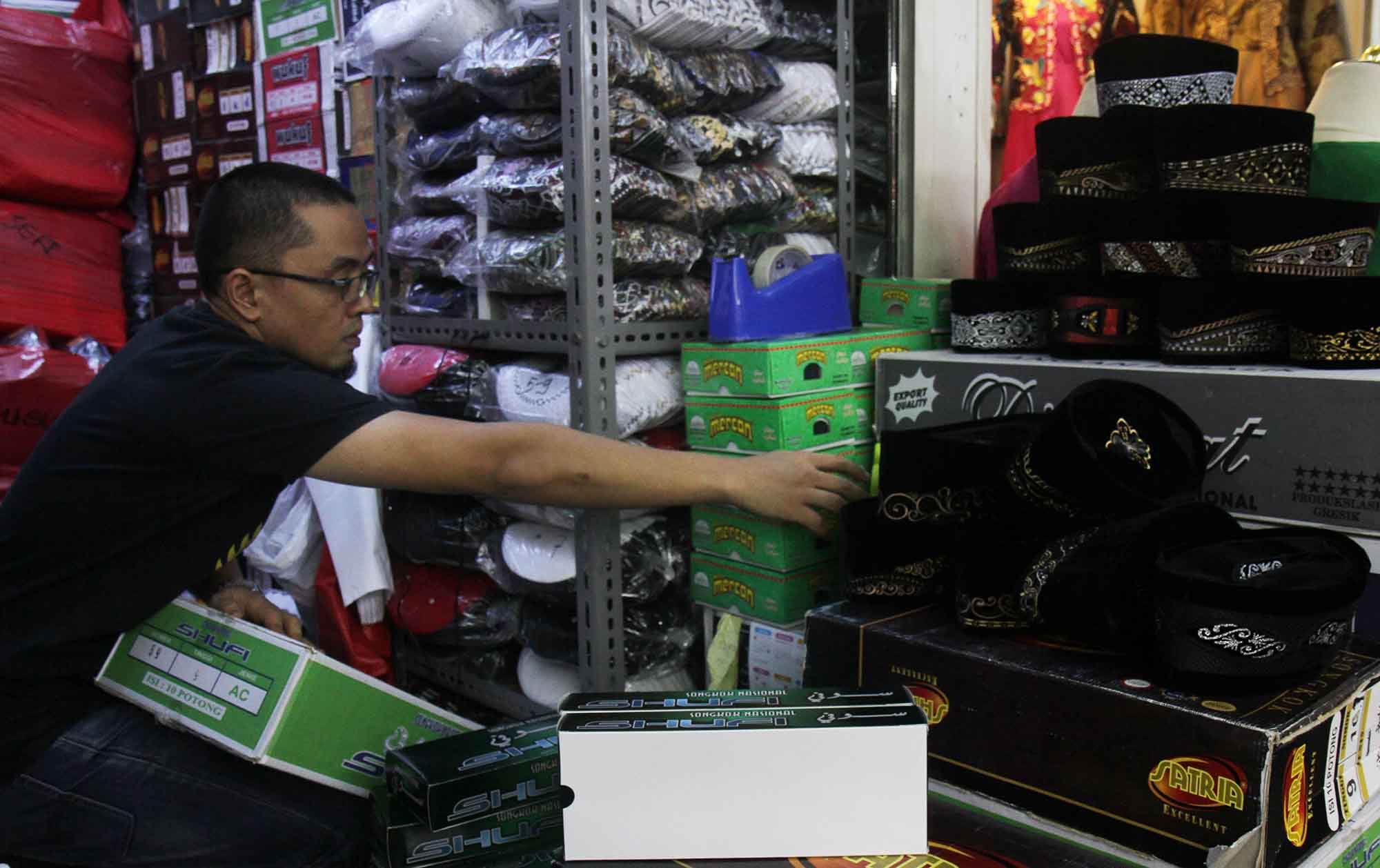 Penjual melayani pembeli peci di Pasar Tanah Abang, Jakarta,Rabu (20/3/2024). (IndonesiaGlobe/Oke Atmaja)