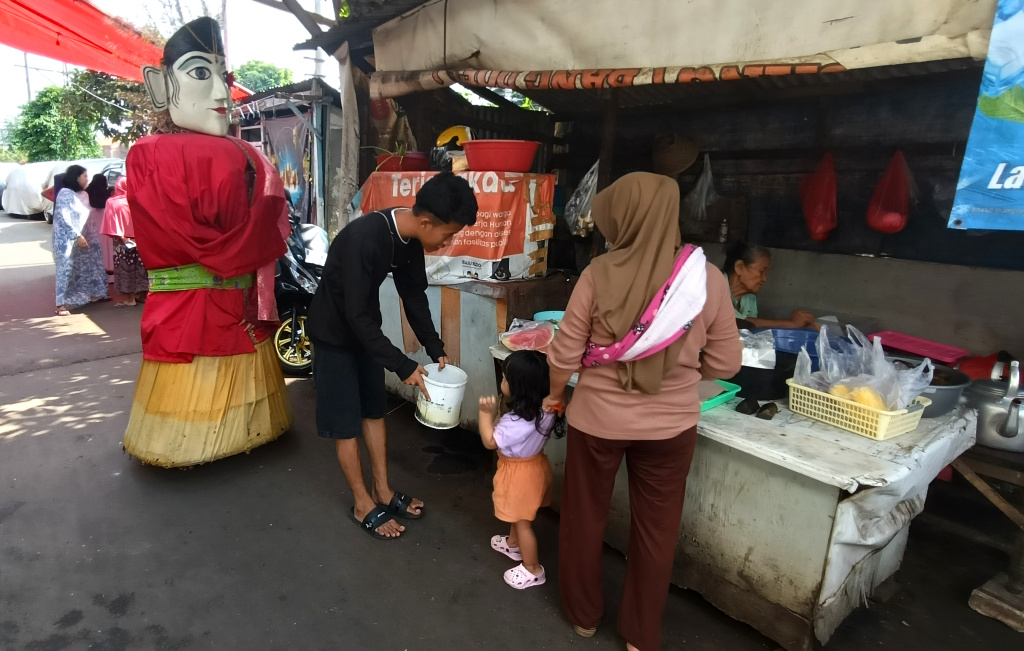 Ondel-ondel Dilarang Ngamen di Jakarta Pengamen ondel-ondel mengamen di perkampungan kawasan Menteng, Jakarta, Rabu (11/6/2025). (Beritanasional.com/Oke Atmaja)