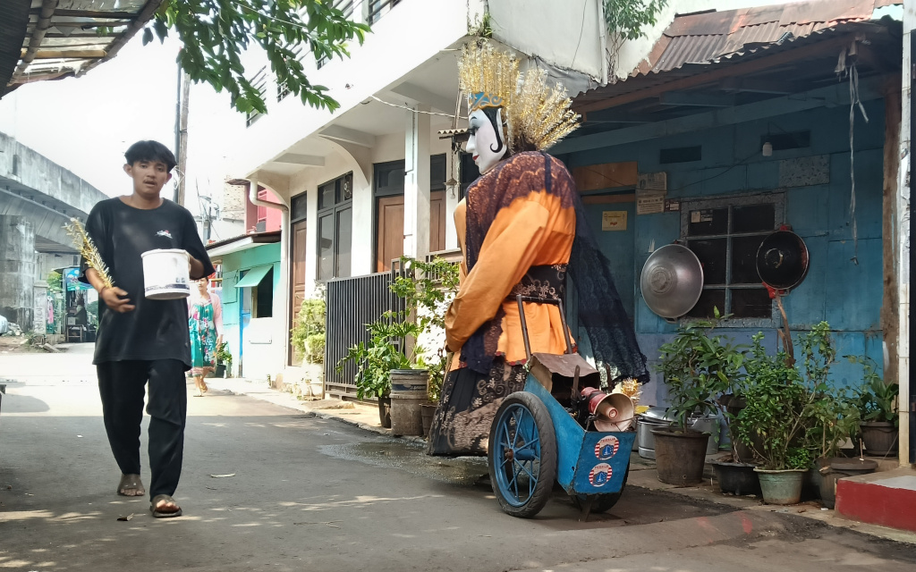 Ondel-ondel Dilarang Ngamen di Jakarta Pengamen ondel-ondel mengamen di perkampungan kawasan Menteng, Jakarta, Rabu (11/6/2025). (Beritanasional.com/Oke Atmaja)