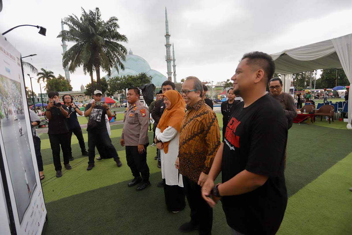Pengunjung mengamati foto yang di pamerkan pada Pameran Foto Jejak Urban Tangkap Dinamika Sosial Banten di Taman Elektrik Puspem Kota Tangerang, Tangerang, Banten, Sabtu (13/12/2025).  (Beritanasional.com/HO/Oke Atmaja)