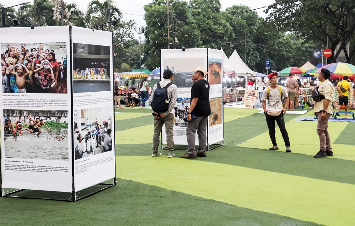 Pengunjung mengamati foto yang di pamerkan pada Pameran Foto Jejak Urban Tangkap Dinamika Sosial Banten di Taman Elektrik Puspem Kota Tangerang, Tangerang, Banten, Sabtu (13/12/2025).  (Beritanasional.com/HO/Oke Atmaja)