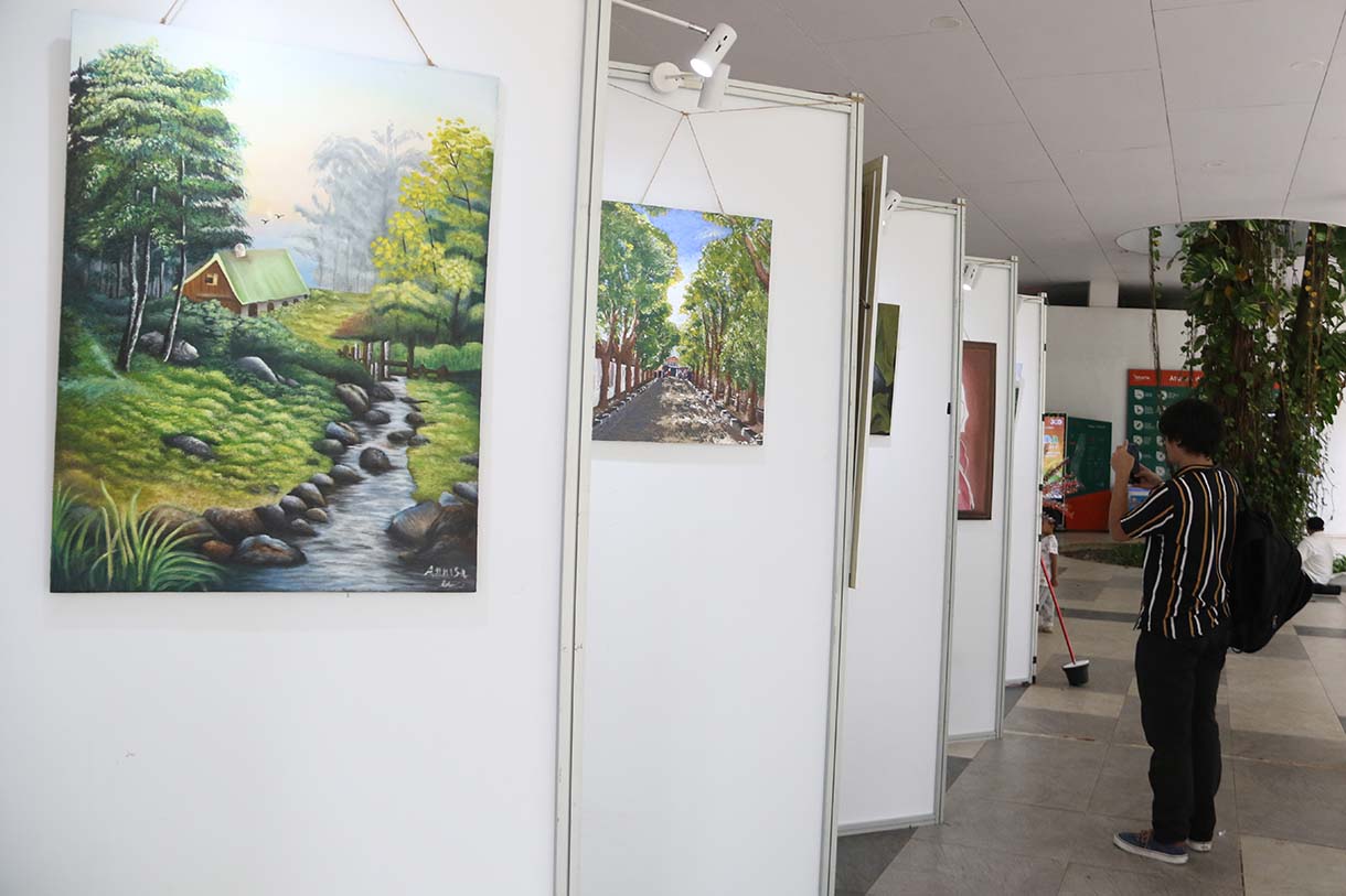 Pengunjung mengamati lukisan dalam pameran Jakarta Artmosphere 2025 di Tebet Eco Park, Jakarta, Selasa (21/10/2025).  (Beritanasional.com/Okeatmaja)