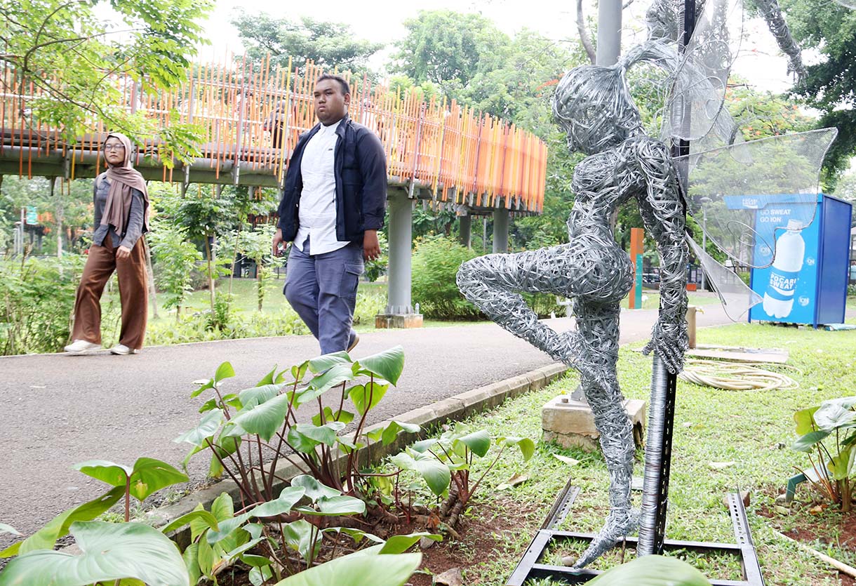 Pengunjung mengamati lukisan dalam pameran Jakarta Artmosphere 2025 di Tebet Eco Park, Jakarta, Selasa (21/10/2025).  (Beritanasional.com/Okeatmaja)